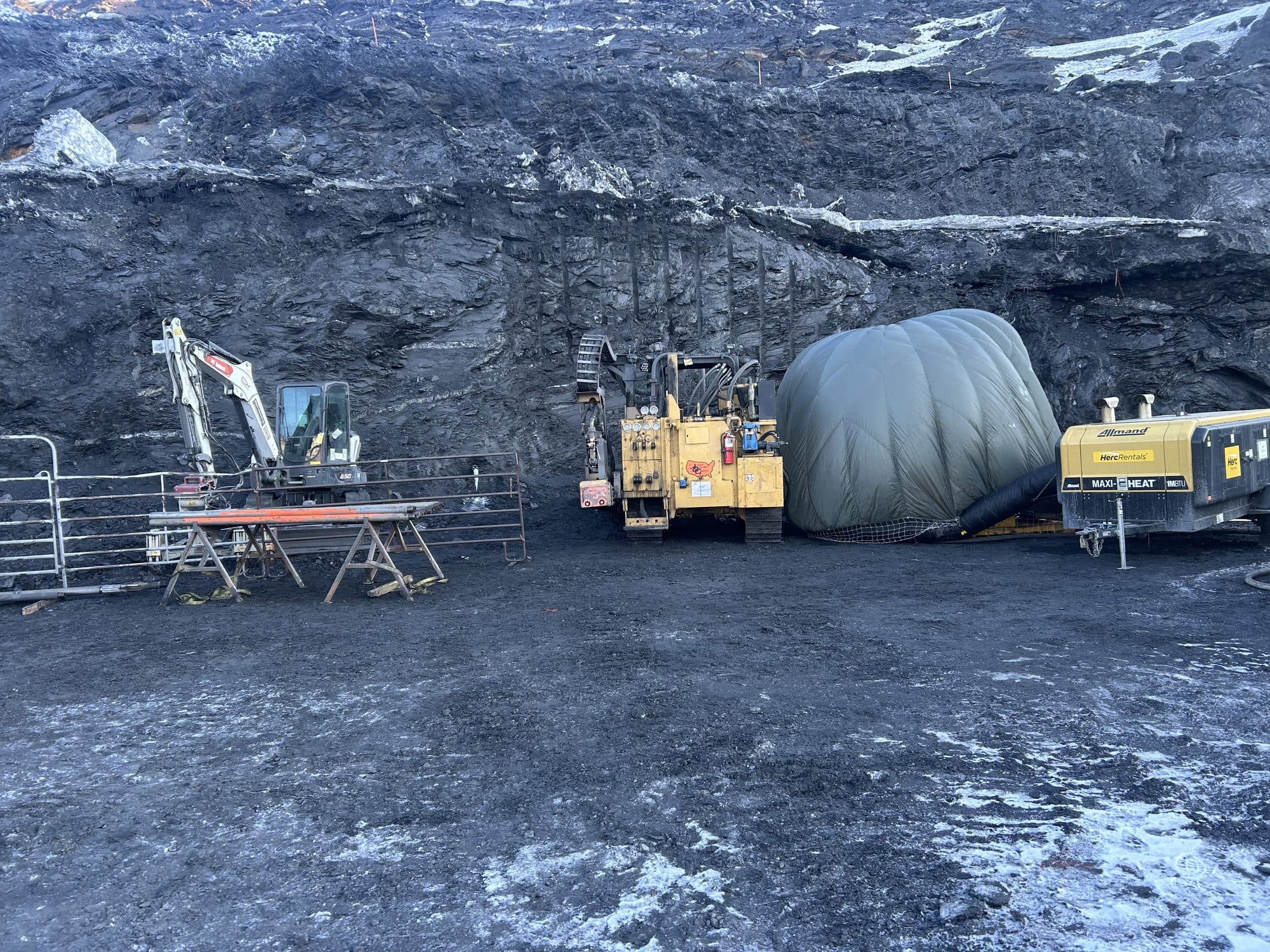Drilling equipment and inflatable heater tent at an Arctic mine highwall